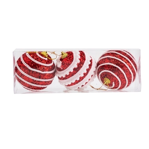 Detailed view of red glitter Christmas balls with white wave patterns in a clear plastic box