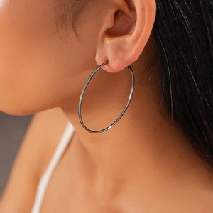 Close-up of a large silver hoop earring worn by a model for a stylish and minimalist look