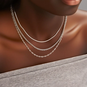 Detail eines mehrlagigen Edelstahl-Schmucksets mit Schlangen- und Kordelkette Collier