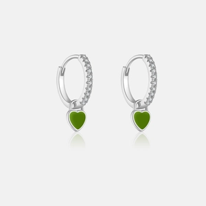 Détail de boucles d'oreilles en argent avec pendentif cœur vert et zircons scintillants