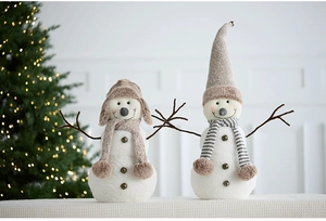 Detail of plush Christmas snowman figurines with knitted hats and cozy festive scarves