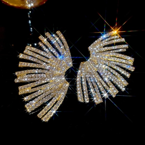 Detail view of gold fan-shaped earrings with micro-set sparkling white rhinestones