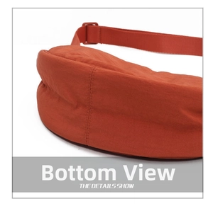 Detail view of the orange nylon crossbody bag base with reinforced stitching and strap buckle
