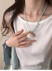 Detailed view of ocean style beaded necklace with shell pendant and starfish detail