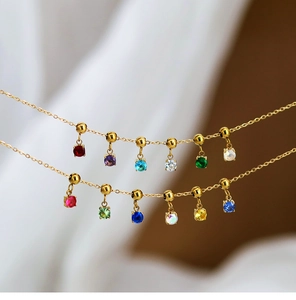 Close-up of 18K gold plated necklaces with multi-colored round cubic zirconia charms