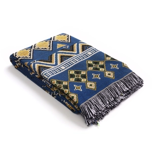 Close-up of bohemian knit blanket with geometric patterns and fringe edges