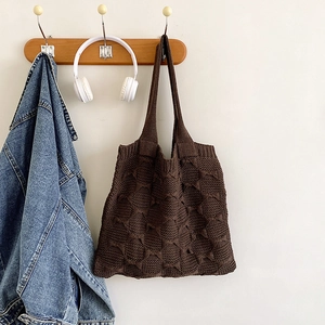 Detail of dark brown knit tote bag showing textured diamond pattern weave and soft material