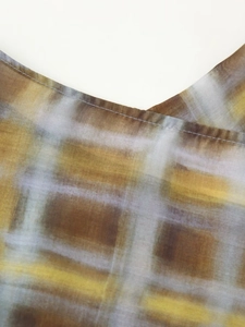 Detailed close-up of brown and blue plaid chiffon fabric showing stitching quality