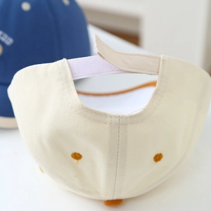 Rear view of a beige baseball cap with adjustable Velcro strap and reinforced stitching