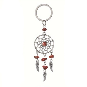 Detail of dreamcatcher keychain featuring silver wing charms and red crystal stones