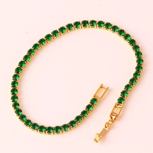 Close-up of gold tennis bracelet featuring emerald green round zircons and secure clasp