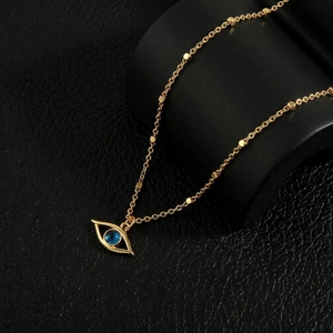 Detail of 18K gold plated evil eye necklace with blue stone and small square beads