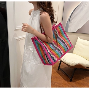 Detailed side view of large rainbow striped woven tote bag with brown handles
