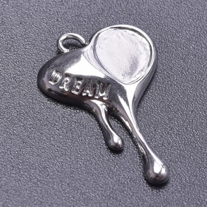 Macro shot of silver stainless steel heart pendant with Dream engraving and melting texture