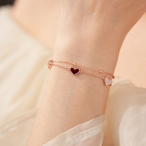 Bracelet double rang cœur or rose avec charms émail rouge et blanc porté au poignet