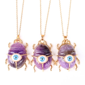 Three gold scarab necklaces with purple amethyst stones and blue evil eye charms