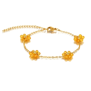 Macro detail of Bohemian gold chain bracelet with four yellow beaded flower charms