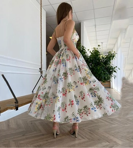 Detail des gekreuzten Rückens und der Blumenstickerei auf einem weißen Maxikleid mit Rückenausschnitt