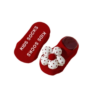 Red baby floor socks with 3D fabric flower and non-slip grips on white background