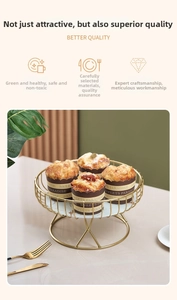 Elegant gold metal cake stand with marble base holding cupcakes in a luxury setting