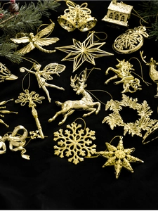 Detailed overhead view of assorted golden Christmas tree ornaments on black velvet