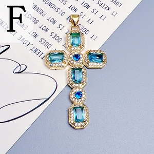 Detailed view of a gold cross pendant with blue zircons and clear crystals on a poetic background