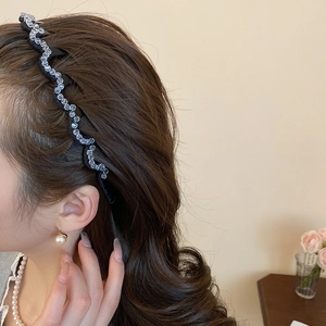 Detail view of wavy rhinestone headband worn by model for elegant hairstyling