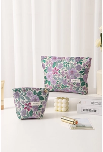Close-up of floral jacquard cosmetic bags with embroidery and golden flower zipper pulls