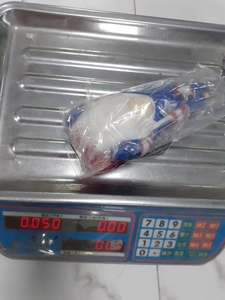 Close-up of patriotic gnome plush on industrial scale showing precise 0.050kg weight
