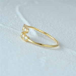 Macro shot of S925 sterling silver gold plated open ring with three sparkling zircons