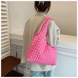 Pink bubble textured shoulder bag styled with a beige blazer and blue jeans