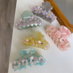 Set of five floral acetate hair claws in pastel colors with sparkling rhinestone centers