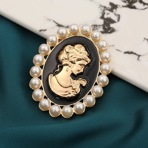 Close-up of vintage cameo brooch with gold female silhouette and pearl border detail