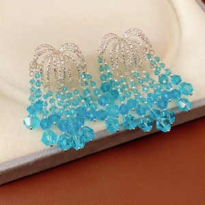 Detail shot of silver fringe earrings with layered blue crystal glass beads on a tray