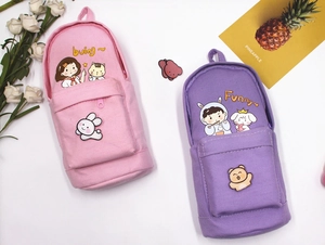 Detail of pink and purple canvas pencil cases with cartoon characters and dual zippers