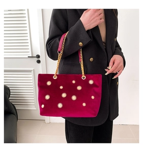 Détail du sac cabas en velours fuchsia avec clous soleil dorés et anse en chaîne