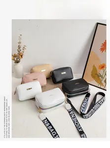 Detail view of multi-colored lychee pattern crossbody bags with trendy wide letter straps
