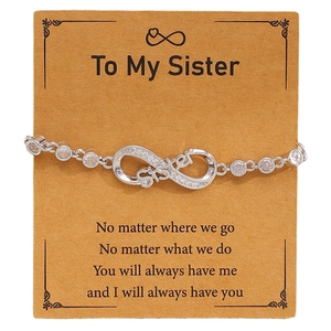 Detailed view of silver infinity sister bracelet with micro-set zircons on brown card
