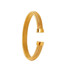 Gros plan d'un bracelet ouvert en C doré présentant une texture filetée à ressort raffinée