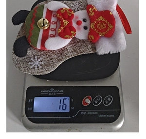 Detail shot showing a 16g snowman plush Christmas ornament on a digital scale