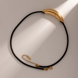 Détail du pendentif tube courbé en or 18k sur cordon noir avec fermoir mousqueton