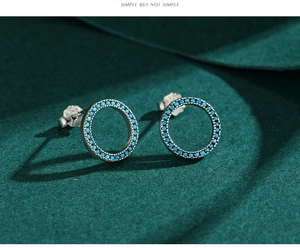 Macro detail of S925 sterling silver round turquoise studs on green velvet