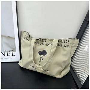 Detail of canvas tote bag with black floral silhouette and NKK ART STUDIO lettering