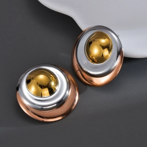 Macro shot of stylish triple-layered wave earrings with gold, silver and rose gold finish