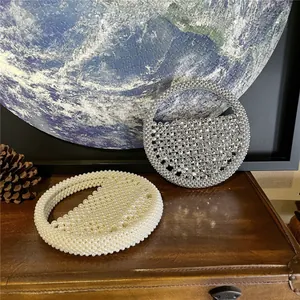 Exquisite pearl and rhinestone circular handbags displayed on vintage leather luggage