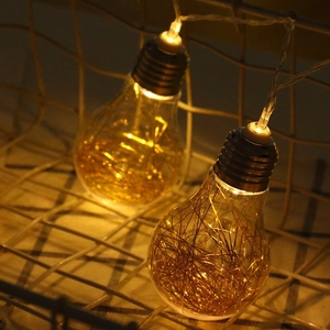 Retro LED copper wire light bulbs in a metal basket with warm yellow decorative glow