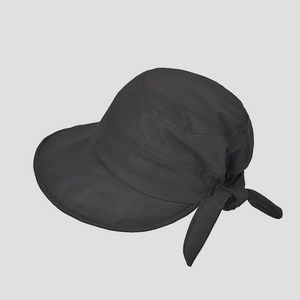 Close-up of women's black sun hat featuring wide brim and decorative bow knot tie