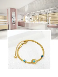 Detailansicht des goldenen Schlangenarmbands mit blauen Perlen und Sonnenanhänger