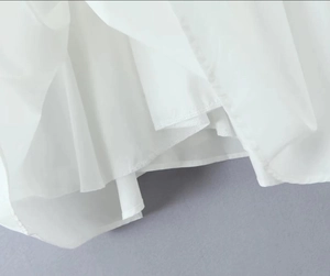Dettaglio ravvicinato dell'orlo in chiffon bianco con cuciture rifinite e trama leggera