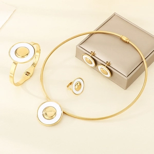 Detailed close-up of a luxury gold and white stainless steel four-piece jewelry set